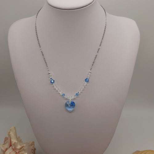 Collana di acciaio con ciondolo di cristallo a forma di cuore in colore acquamarina circondato da piccoli cistalli di diverse misure 